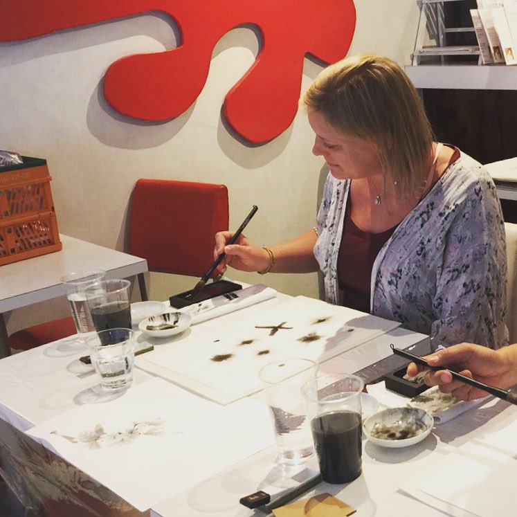 墨絵の体験をしているツーリストの女性